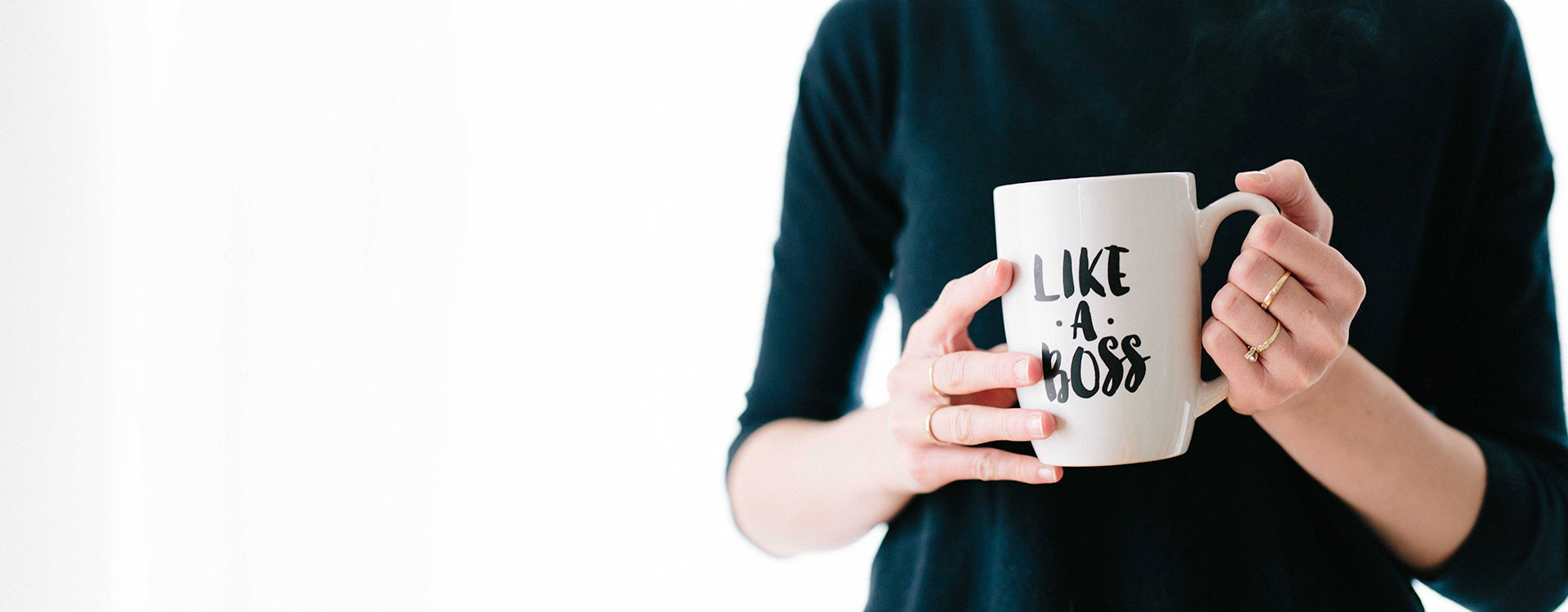 We see female hands holding a mug with the words "like a boss" written on them