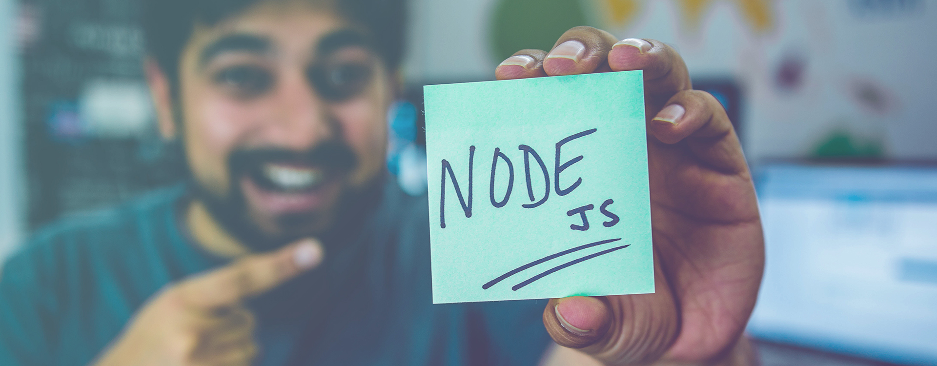 Man holds post it with Node.JS written on it