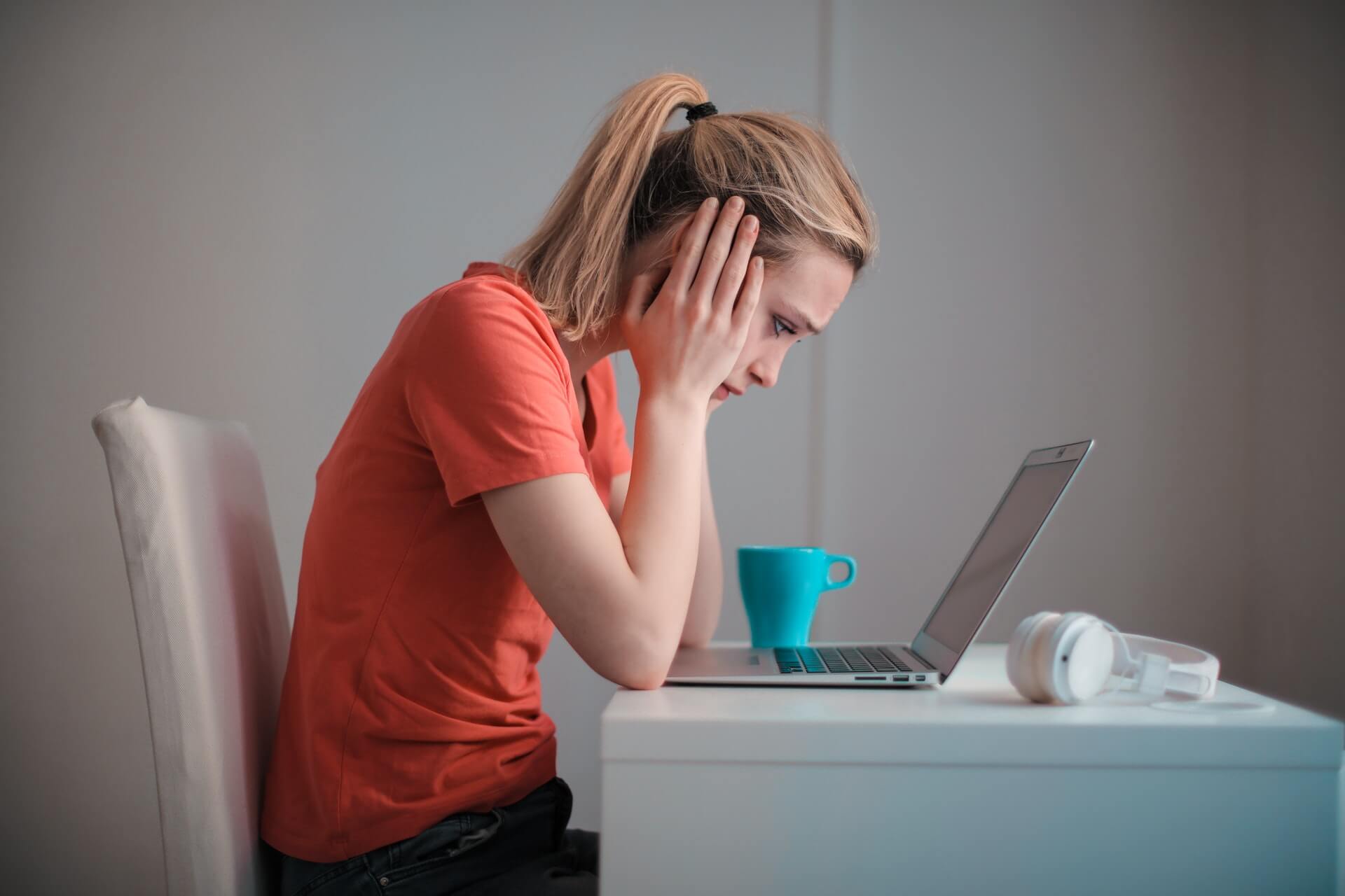 Unsatisified female employee looks sadly at computer