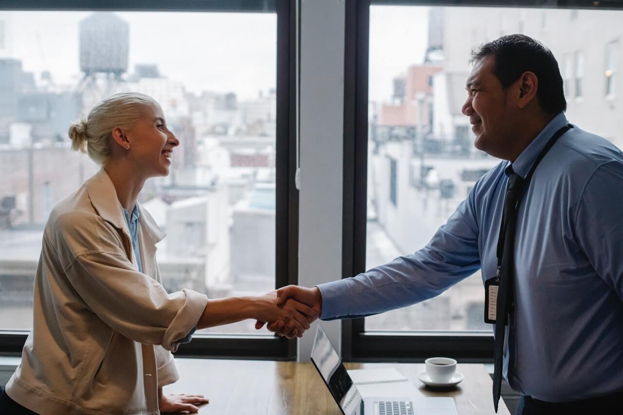 Cheerful colleagues shake hands after interview